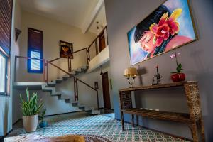 a living room with stairs and a painting on the wall at Dolce Vita Guest House in Lagoinha