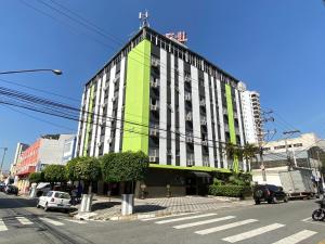 a green and white building on a city street at VOA San José Palace Hotel in Osasco