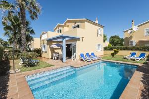 a villa with a swimming pool in front of a house at Villas Amarillas in Cala Blanca