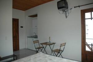 a bedroom with a table and chairs and a kitchen at Elenis Olive green Studio in Petra