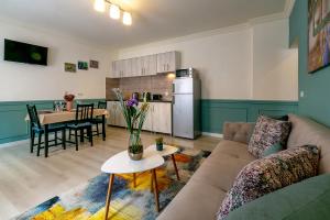 ein Wohnzimmer mit einem Sofa und einem Tisch sowie eine Küche in der Unterkunft Smart Apartments in Sighişoara