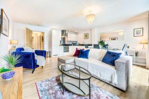 a living room with a white couch and blue pillows at Self-contained town centre apartment Queensgate nr Marketfield by Helmswood Serviced Apartments in Redhill
