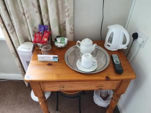 a table with a tea set on top of it at Swiss Guest House in Castleton