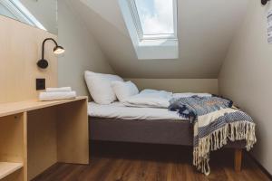 a small bed in a room with a window at Han Sylte Bed and Breakfast in Fauske