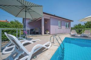 uma piscina com cadeiras e um guarda-sol ao lado de uma casa em Adorable Holiday House Lilla-with pool-near Old Town Labin em Labin