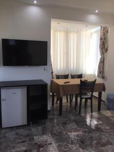 a dining room with a table and a television on a wall at Sunset Apart Otel in Oludeniz