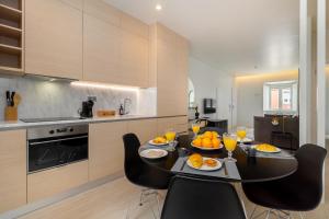 里斯本的住宿－Beato HUB Residences | Perfect for Digital Nomads & Families，厨房配有带橙子的桌椅