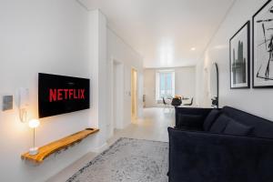 里斯本的住宿－Beato HUB Residences | Perfect for Digital Nomads & Families，客厅配有沙发和墙上的电视