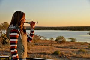 a woman is drinking a glass of wine at Kameeldrift Waterfront Estate & Resort in Brits