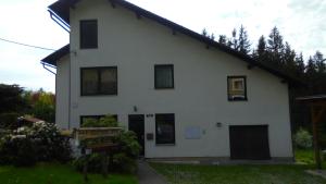 a white house with black windows at Apartman Aya in Janov nad Nisou