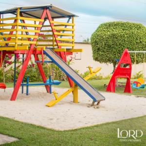 einen Spielplatz mit Rutsche im Sand in der Unterkunft Hotel Pousada Lord in Teixeira de Freitas