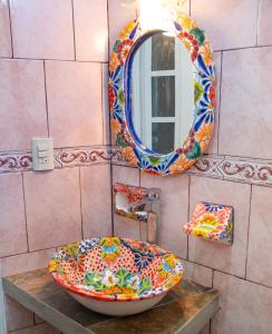 ein Badezimmer mit einem bunten Waschbecken und einem Spiegel in der Unterkunft Casa Lomas del Marinero Internet Starlink SIN GARAJE in Puerto Escondido