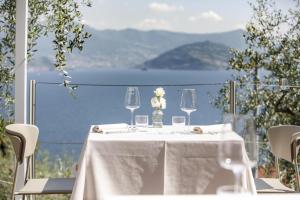 a table with a white table cloth and wine glasses at Hotel Miranda in Riva di Solto