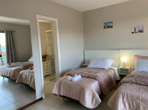 a bedroom with two beds and a mirror at Avenida Center Hotel in Uruguaiana