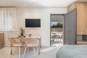 - une chambre avec un lit, une table et des chaises dans l'établissement Margiani Studio, à La Canée