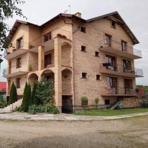 ein großes Backsteingebäude mit Balkonen darauf in der Unterkunft Pokoje Gościnne Grzybowo in Grzybowo