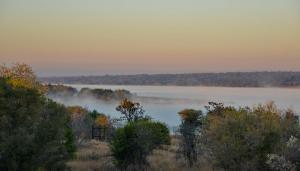 una vista de un lago con niebla a lo lejos en Kameeldrift Waterfront Estate & Resort, en Brits