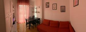ein Wohnzimmer mit einem roten Sofa und einem Tisch in der Unterkunft Casa Bianca 6 - confortevole in centro a Moneglia in Moneglia