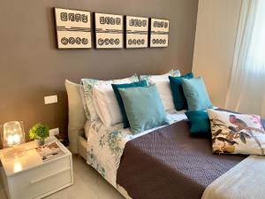 a bedroom with a bed with blue and white pillows at Villa Luminosa in Torre del Lago Puccini
