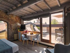 ein Zimmer mit Bett und Balkon mit Tisch und Stühlen in der Unterkunft Cangrande Hotel in Lazise