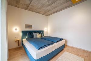 een slaapkamer met een groot bed en een blauwe deken bij Apartment Das Eckige in Cermes