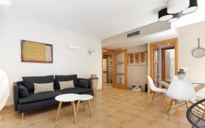 a living room with a black couch and a table at Lets Holidays new apartment close to the beach in Tossa de Mar