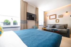 una camera d'albergo con un letto e un divano di Résidence du Louvre a Parigi