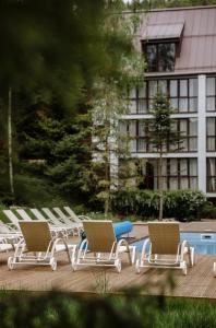 eine Reihe von Liegestühlen neben einem Pool in der Unterkunft Yaremche Club Hotel in Jaremtsche