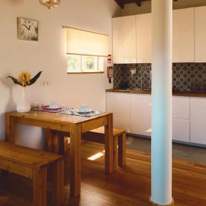 Quinta das Almas في ساو روكي دو بيكو: مطبخ مع طاولة خشبية في الغرفة