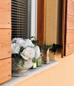 a vase filled with white flowers on a window sill at Villa Dora in Pag