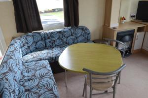 a living room with a couch and a table at Golden Palm Resort Sherwood 6 Berth Club Tropicana Chapel St Leonards in Skegness