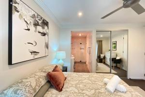 - une chambre avec un lit et une peinture murale dans l'établissement Maverick's Retreat Cromer Sydney's Northern Beaches, à Collaroy