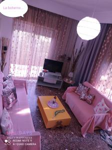een woonkamer met een bank en een tv bij The star la boheme!!! in PalaiónTsiflíkion
