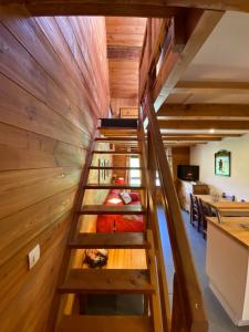 uma escada em espiral num quarto com paredes de madeira em LE PASSE-MONTAGNE Bel appartement avec terrasse dans vieille ferme de montagne rénovée em Les Orres