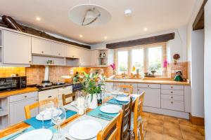 a kitchen with a dining room table and chairs at Rose Barn Cotswolds with Hot Tub in Langford