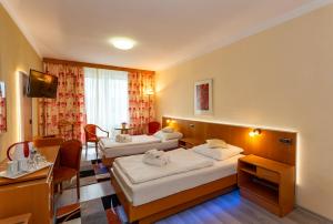 切爾瑪波蘇馬維的住宿－Fontána Lipno，酒店客房设有两张床和一张桌子。