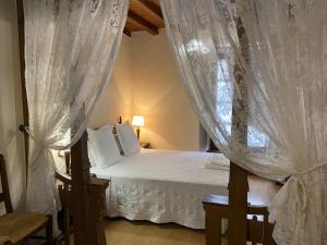 a bedroom with a bed and a window with curtains at Hotel rural Rinconada de las Arribes in Aldeadávila de la Ribera
