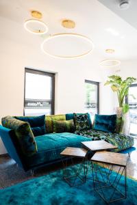 a living room with a blue couch and two tables at Hotel Modus in Salzburg