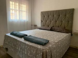 una camera con un letto con due cuscini sopra di Apartamento con jardín y piscina en el faro de calaburras a Mijas Costa