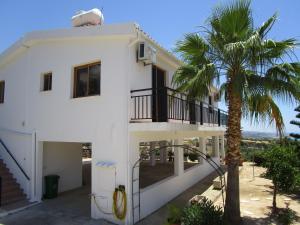 a white house with a palm tree in front of it at Serene Serenity in Paphos