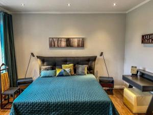 a bedroom with a bed with a blue comforter and a piano at Villa Zwölf in Soltau