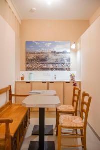 波爾多的住宿－Une chambre à l'Economat，厨房配有桌椅和墙上的绘画作品