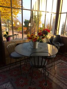 een tafel en stoelen met een vaas met bloemen erop bij Le Domaine de Dony in Balbins
