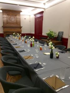 Le Domaine de Dony في Balbins: طاولة طويلة في قاعة المؤتمرات مع الكراسي والورود