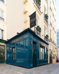 una vetrina blu di fronte a un edificio di Résidence du Louvre a Parigi