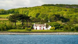 ein weißes Haus am See in der Unterkunft Mount Vernon, Clare in Karstlandschaft Burren