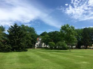une grande pelouse avec une maison en arrière-plan dans l'établissement Villa Zwölf, à Soltau