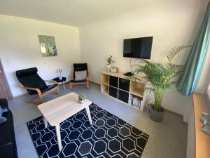 a living room with a table and a tv at Apartments Carmena in Saas-Grund