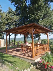 einen hölzernen Pavillon mit einem Tisch im Garten in der Unterkunft La Casa dei Nonni in Chianni