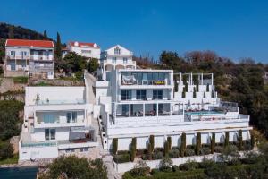 duży biały dom na szczycie wzgórza w obiekcie Luxury Villa Malena with private heated pool and amazing sea view in Dubrovnik - Orasac w mieście Zaton